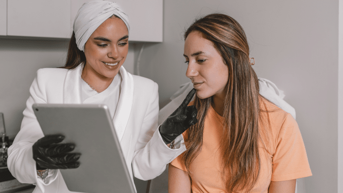 Doctor examining female patient's skin and explaining how Dermalax will work.
