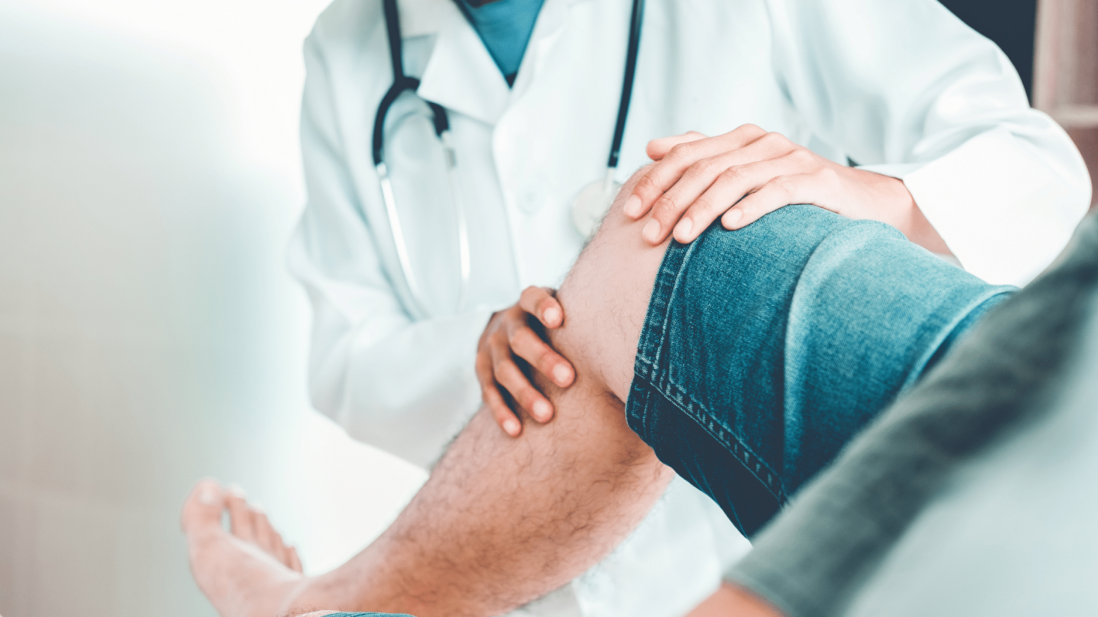 A healthcare professional assesses the knee joint of a patient.