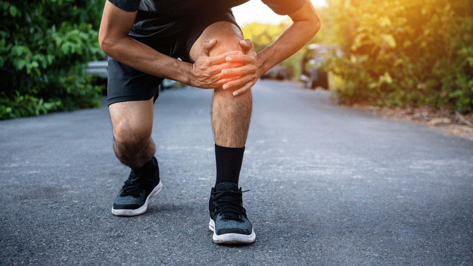 A person stops mid-jog after feeling knee pain.