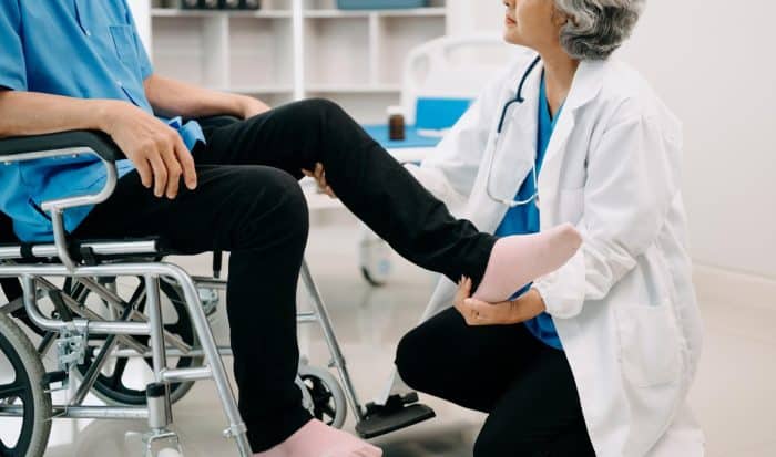 A patient with knee pain caused by osteoarthritis is examined by a specialist.