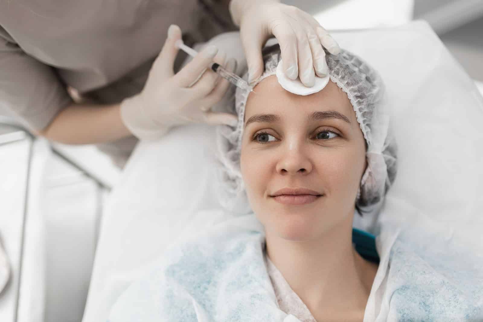 Patient receiving Botox injection to treat forehead wrinkles.