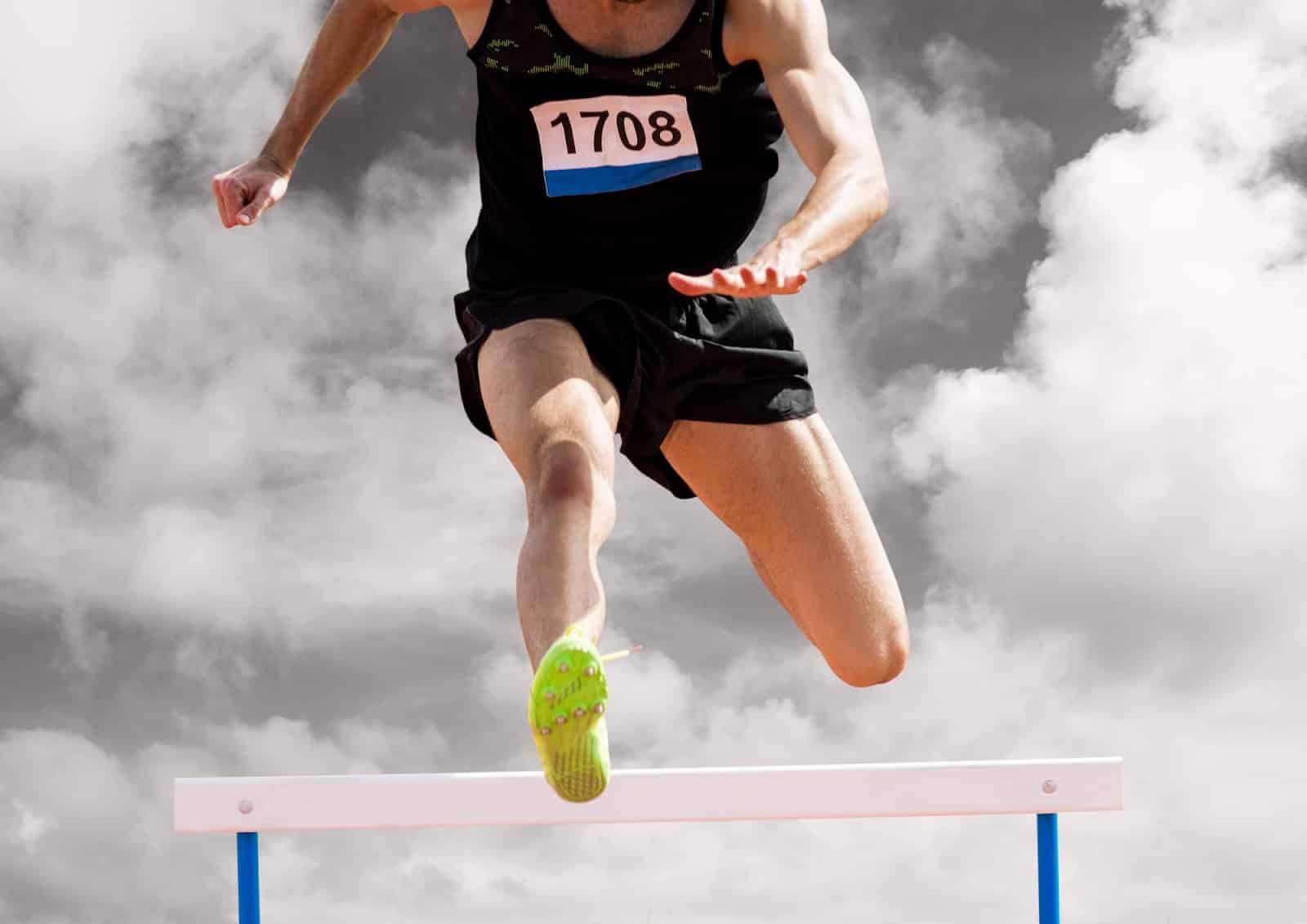 A fit athlete with healthy joints jumping over a hurdle.