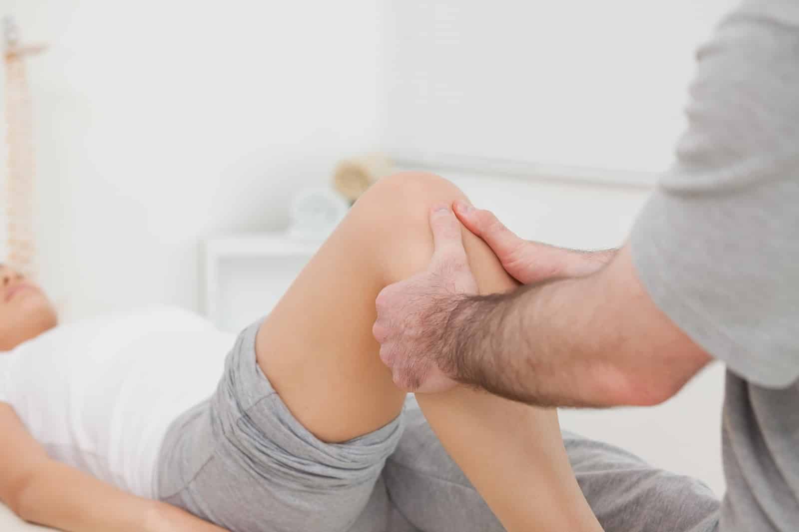 Specialist carefully inspecting the strength of an Orthovisc patient's knee joint after treatment.