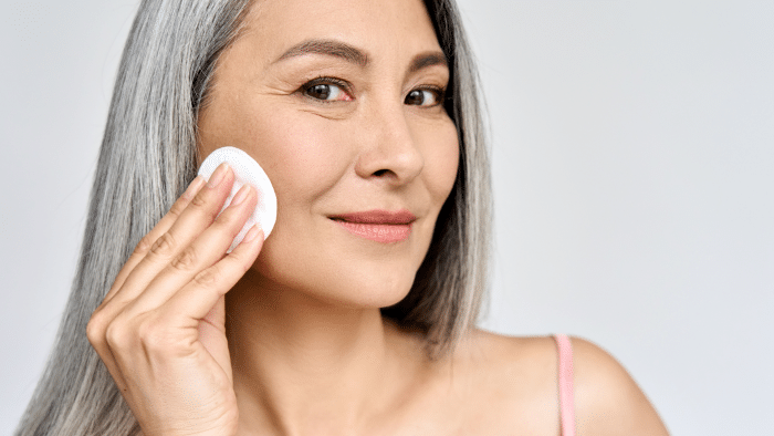 Woman performing her antiaging skincare routine.
