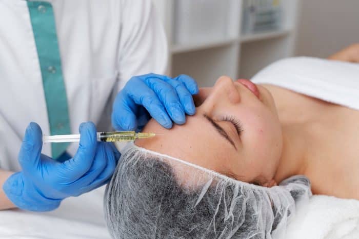 A healthcare professional injects Dysport into the forehead for hyperhidrosis.
