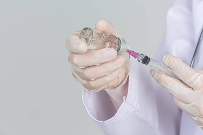 A healthcare professional carefully prepares Dysport injection before treatment,