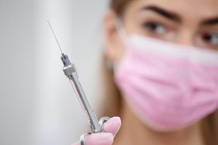 A healthcare professional holding up a syringe of Dysport.