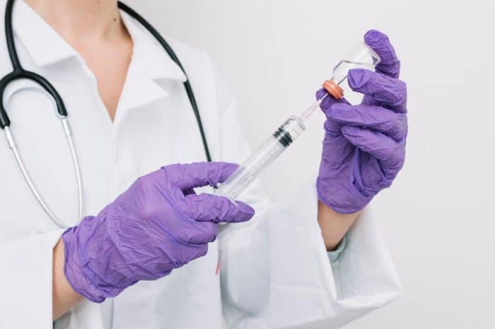 Healthcare professional carefully preparing Dysport injection before treatment.