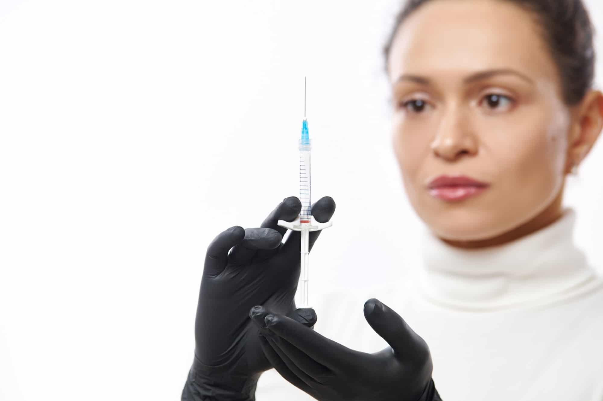A female aesthetic specialist holds up a syringe of Dysport.