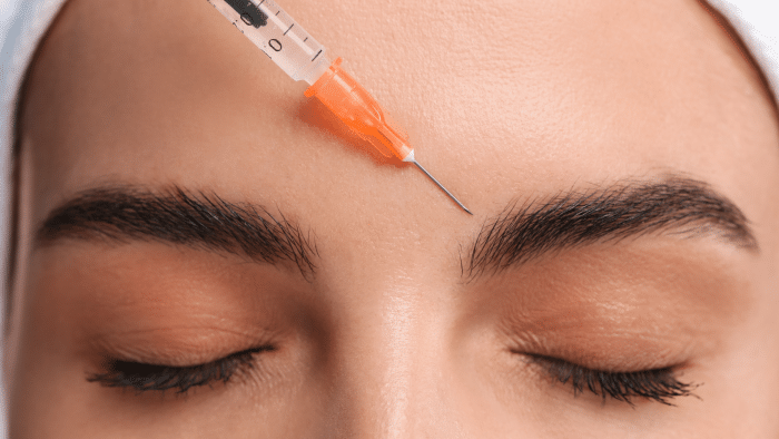 Woman getting forehead injection.