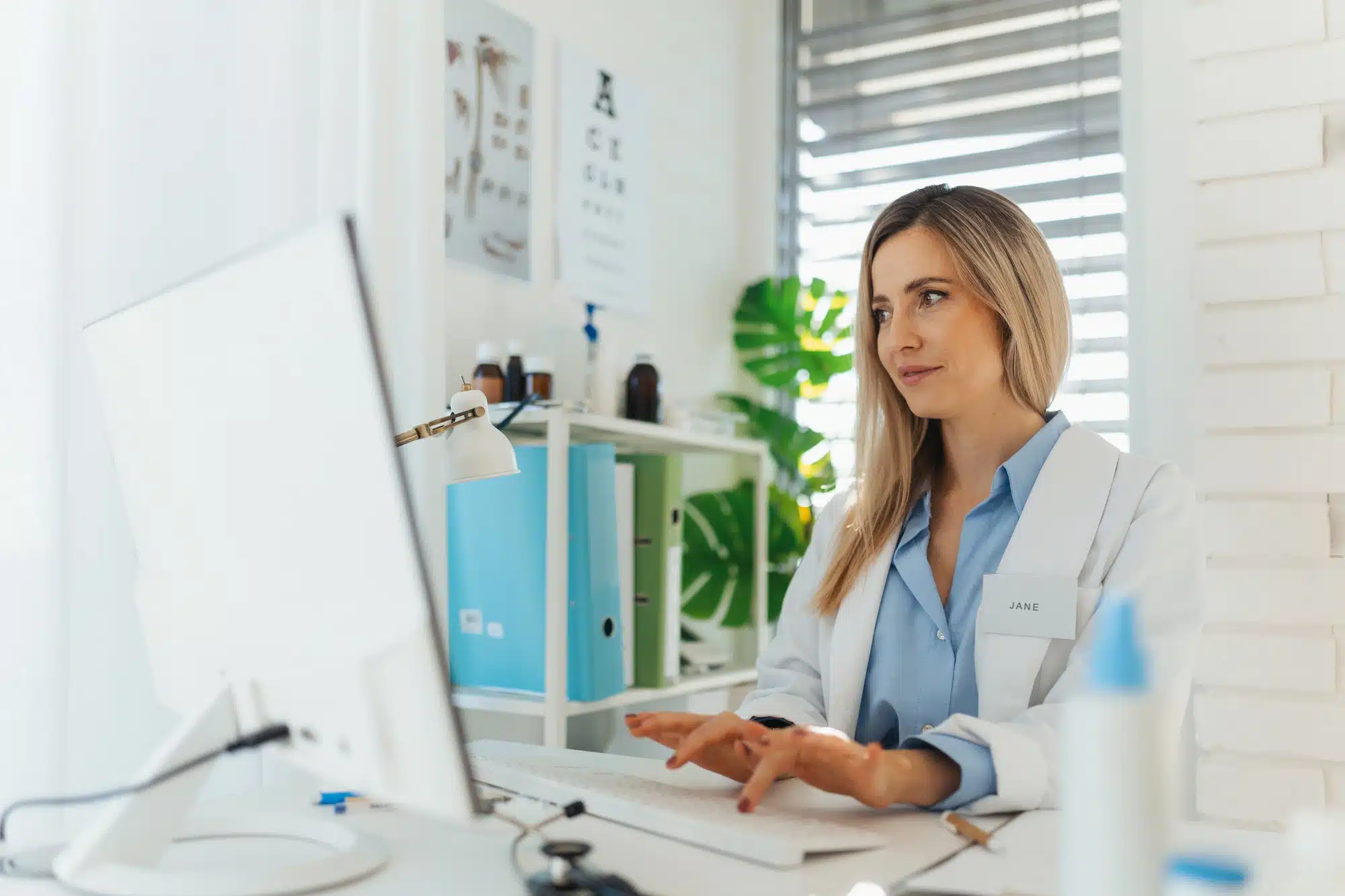aesthetic doctor typing on a laptop