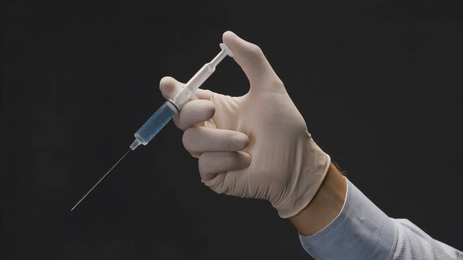 A healthcare professional holding a syringe.