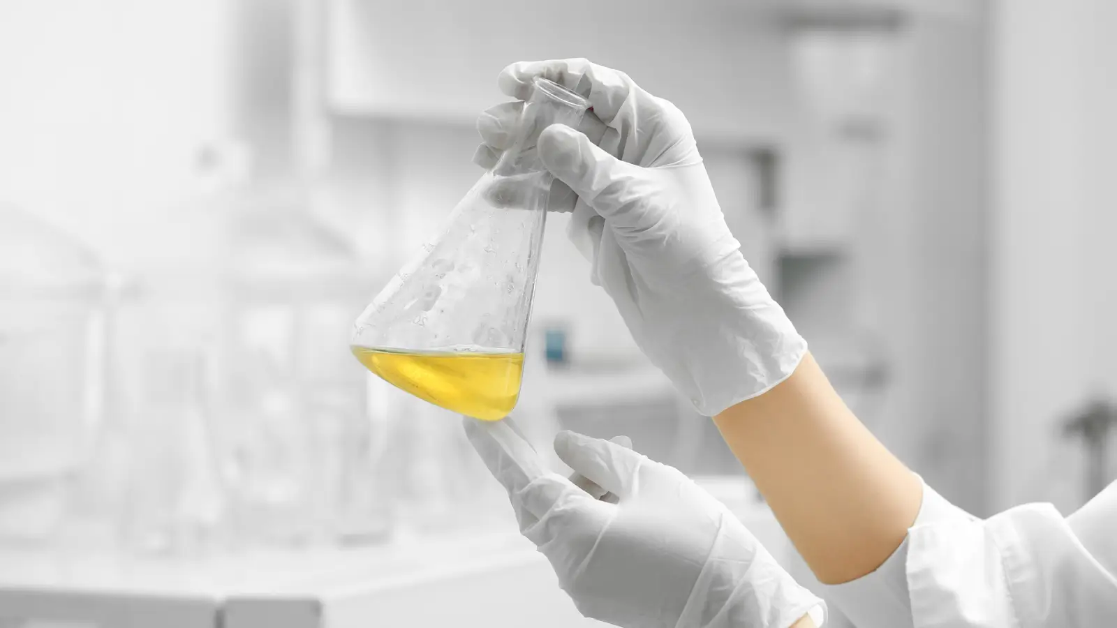 Expert examining and holding a scientific flask.