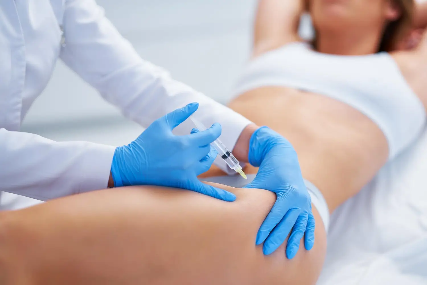 Woman getting an injection for body sculpting.