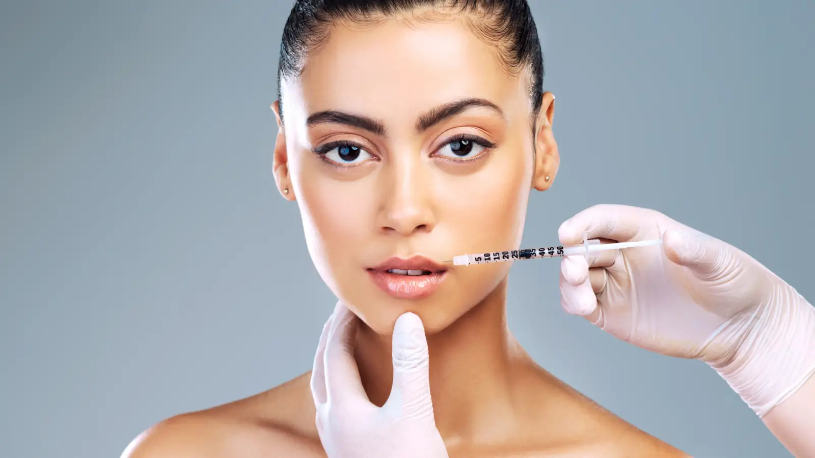 A woman receiving filler treatment for lip augmentation.