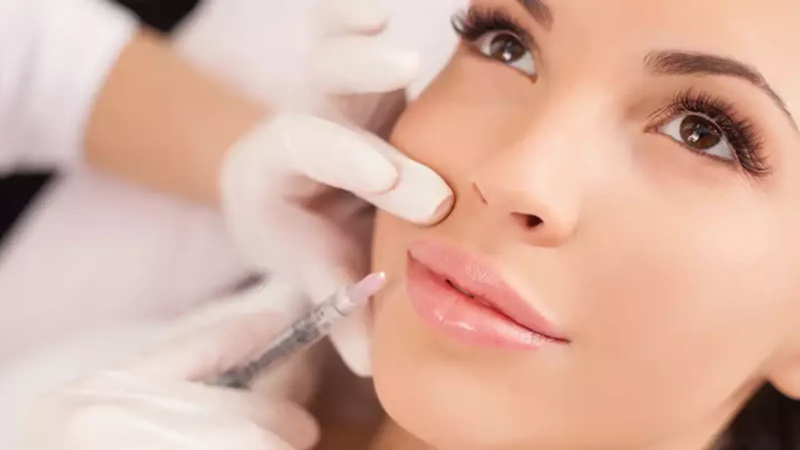 Woman receives filler injection for facial enhancement.