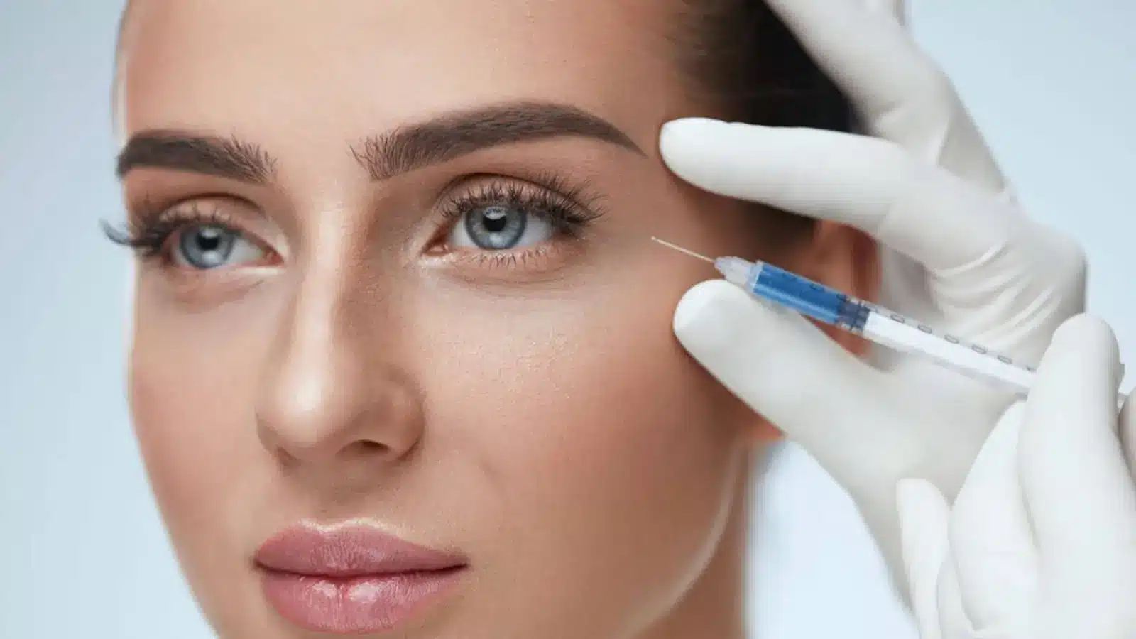 Doctor carefully injecting filler for rejuvenation.