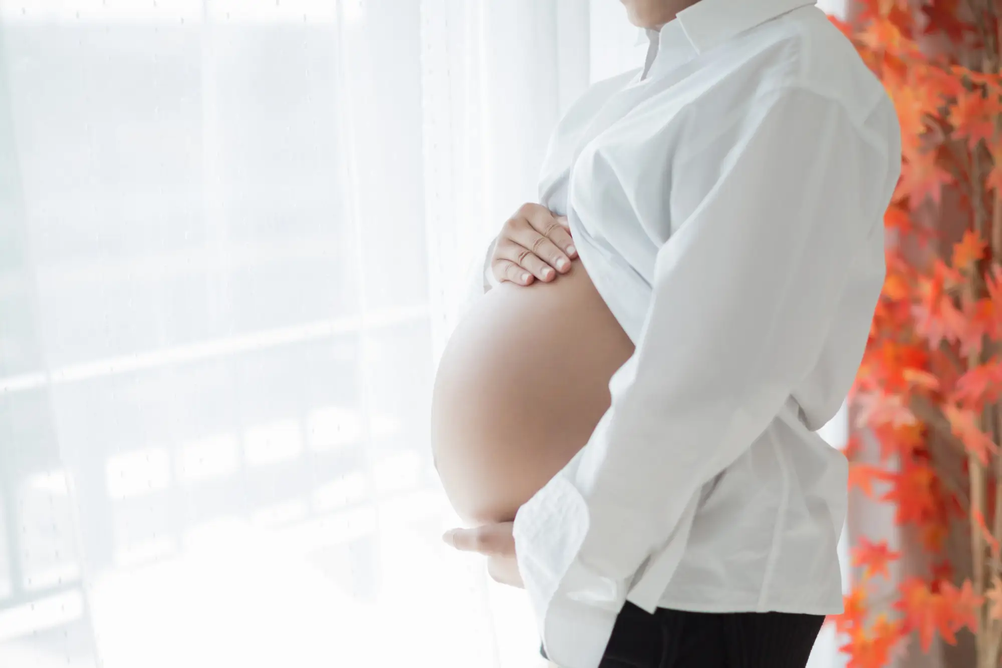 Pregnant woman cradling her stomach.