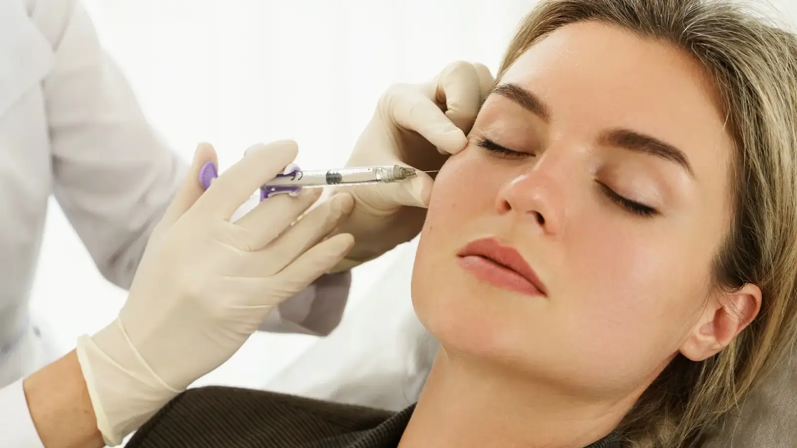 Woman getting a facial injeciton.
