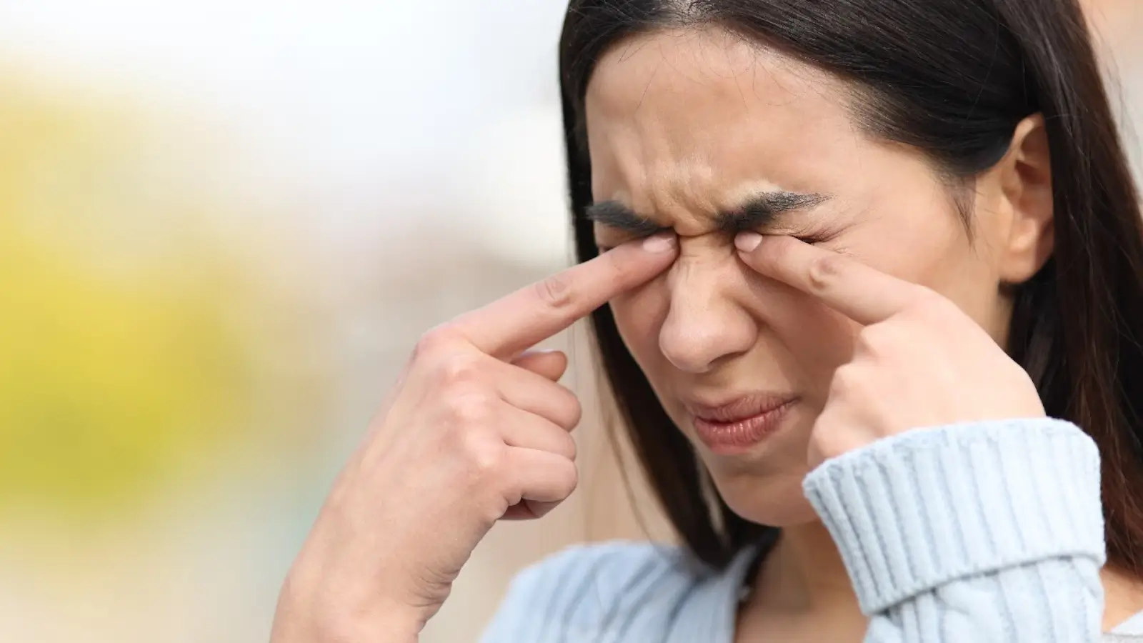 Lady rubbing her eyes.