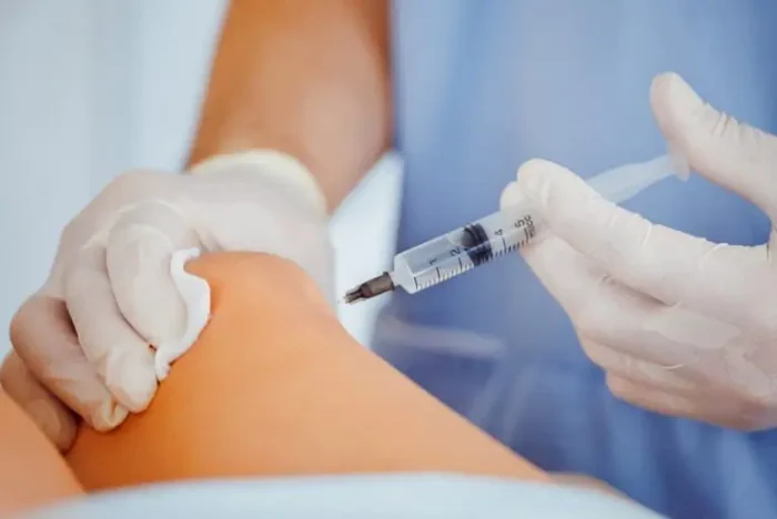 Doctor injecting knee. 