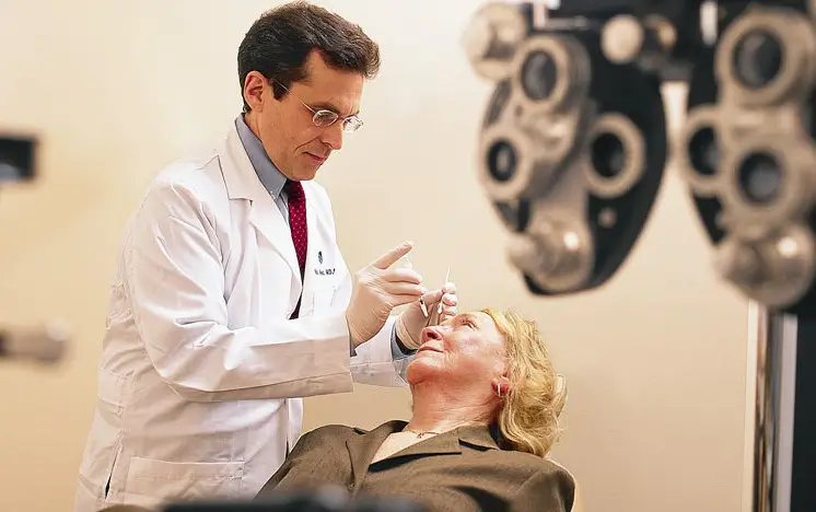 Doctor checking eyes of person.