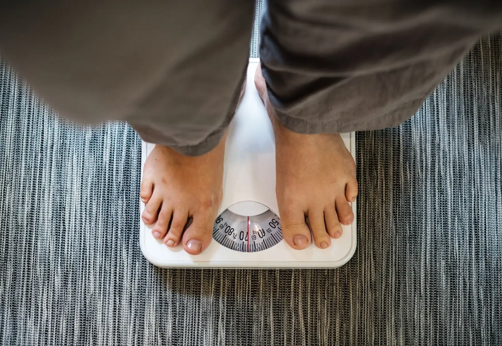Person standing on a weighing scale. 
