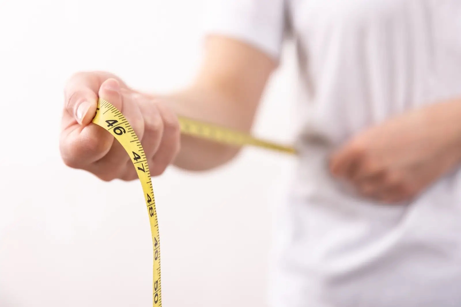 Person holding a measuring tape. 